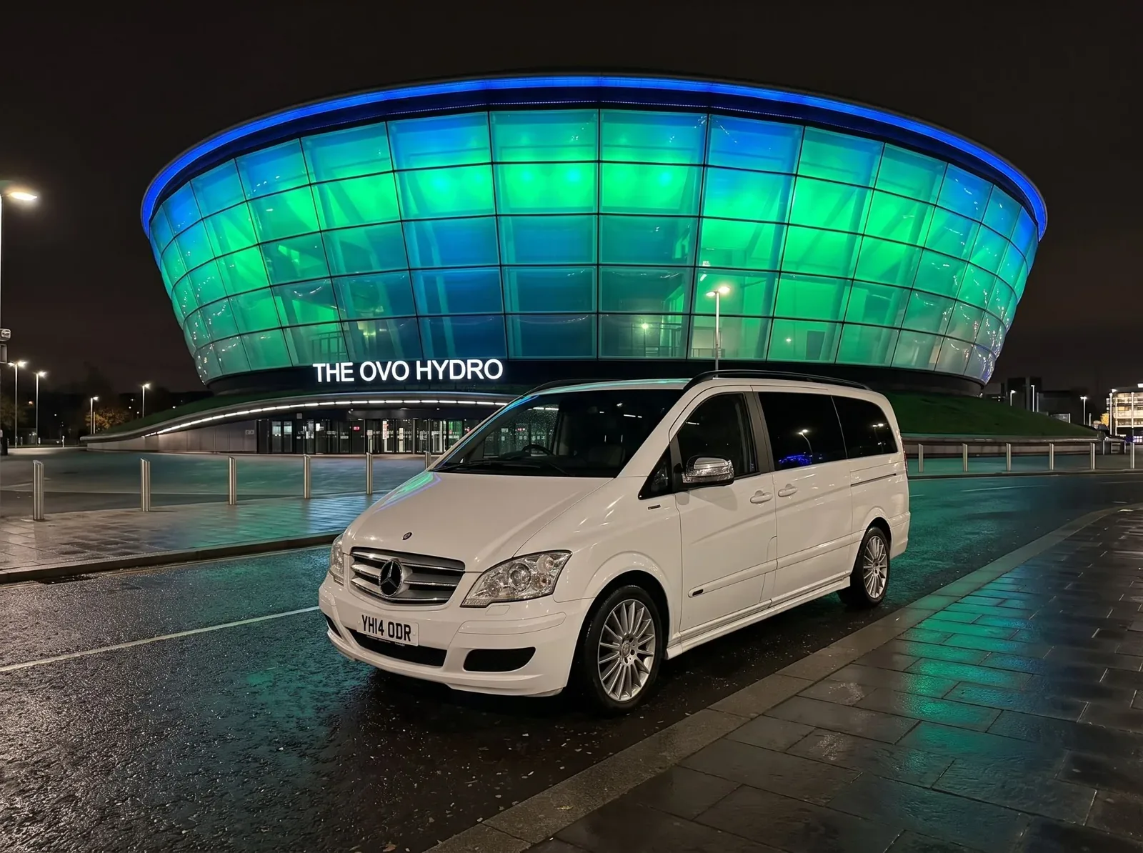 White Mercedes 9-seater outside The OVO Hydro in Glasgow at night